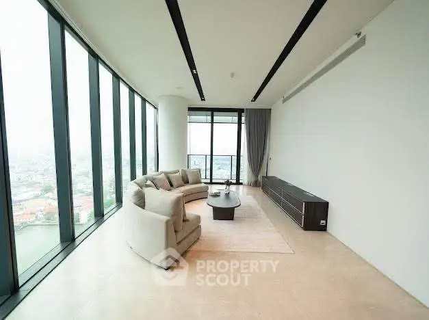 Spacious modern living room with panoramic city views and elegant furnishings.
