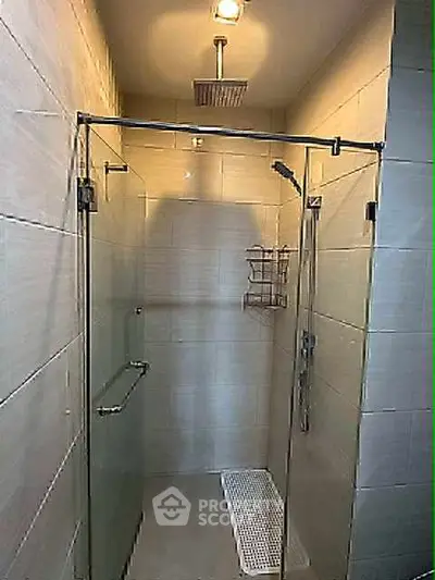 Modern shower area with glass enclosure and overhead rain shower