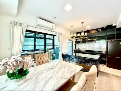 Luxurious open-plan kitchen and dining area with marble table and modern appliances.
