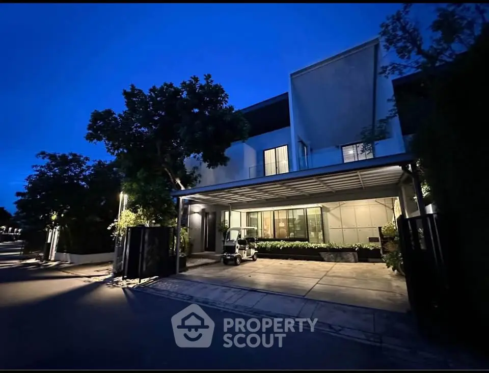 Modern luxury home exterior with sleek design and spacious driveway at dusk.