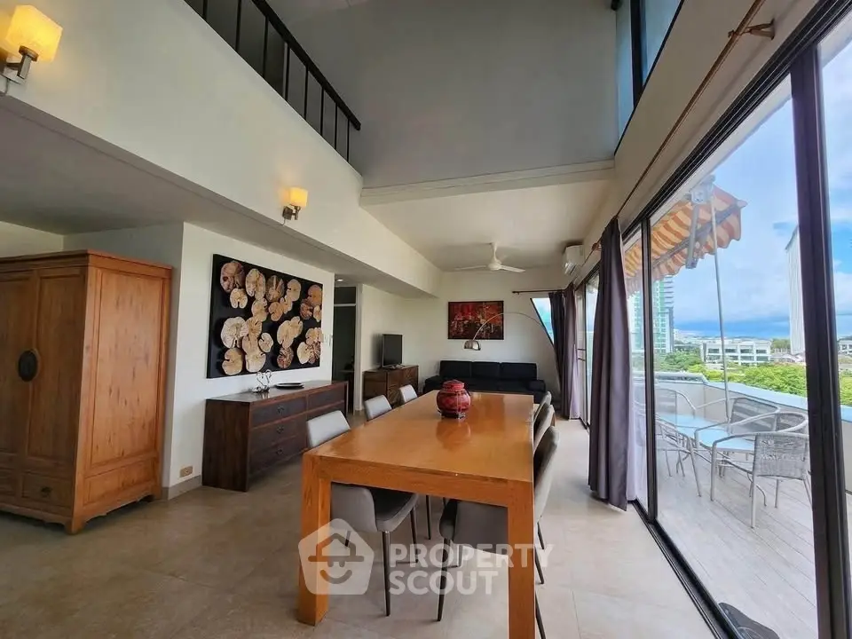 Spacious modern living room with large windows and balcony offering stunning city views.