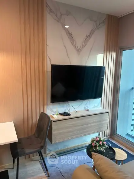Modern living room with wall-mounted TV and stylish decor in a cozy apartment setting.