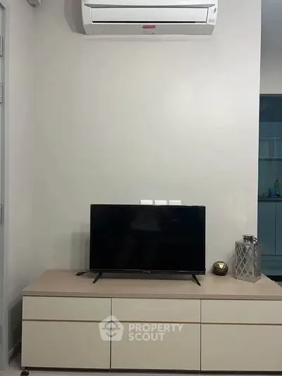 Modern living room with sleek TV setup and air conditioning unit, perfect for comfortable living.