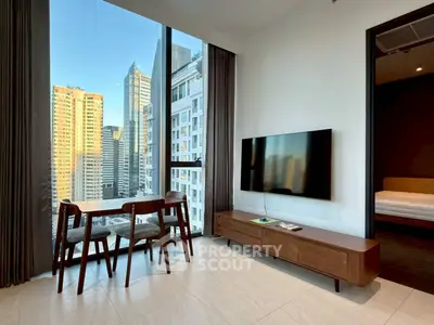 Modern living room with city view, sleek furniture, and large windows in high-rise apartment.