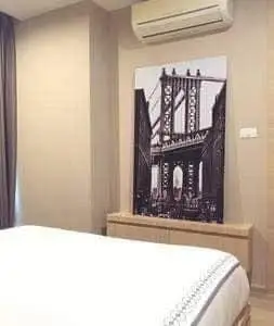 Cozy bedroom with modern decor and air conditioning, featuring stylish wall art.