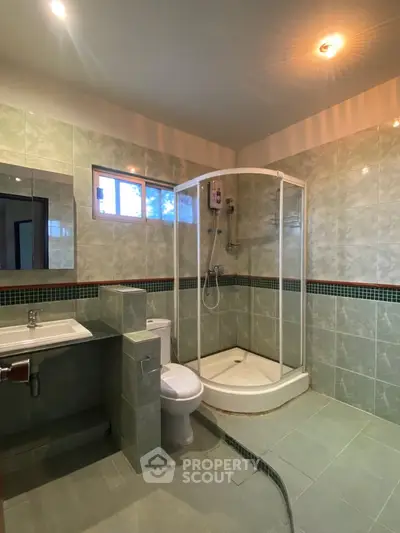 Spacious modern bathroom with glass shower and elegant tile design