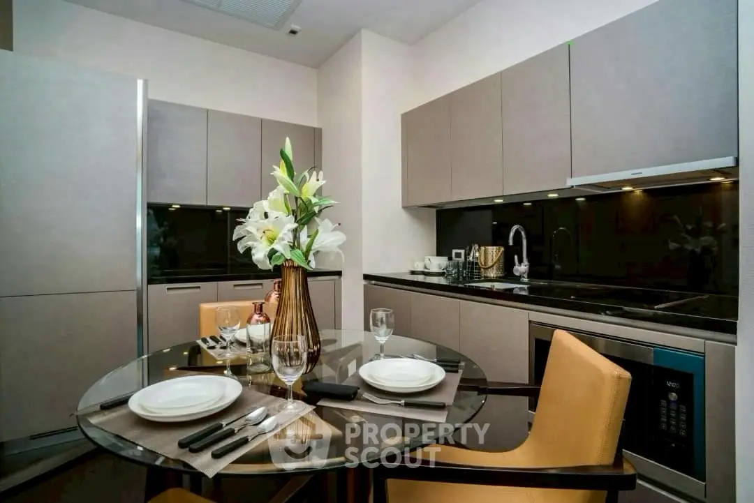 Modern kitchen with sleek cabinetry and elegant dining setup in a stylish apartment.