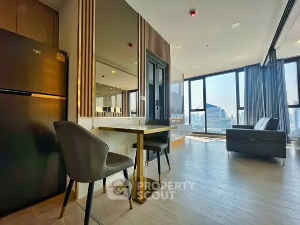 Modern living room with city view, featuring sleek furniture and large windows for natural light.