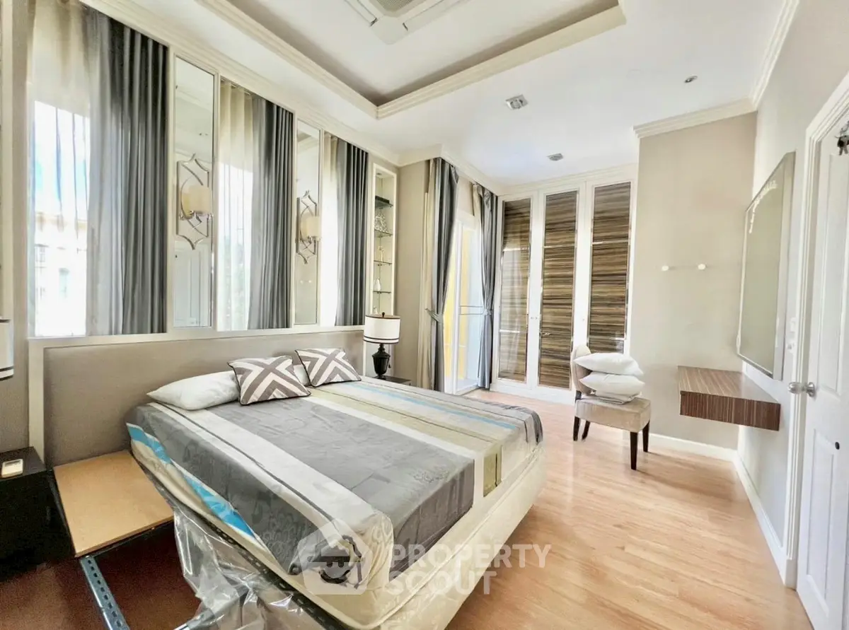 Luxurious bedroom with elegant decor and ample natural light in modern home.