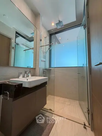 Modern bathroom with glass shower and sleek vanity in luxury apartment
