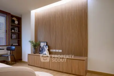 Modern living room with elegant wooden paneling and built-in storage, perfect for stylish urban living.