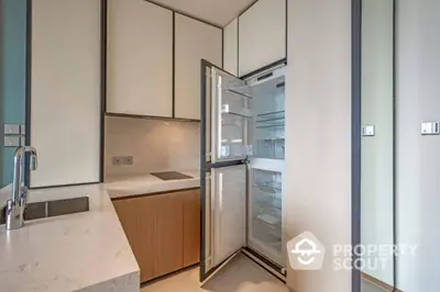 Modern kitchen with open fridge and sleek cabinetry