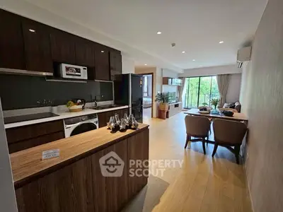 Modern open-layout kitchen and living area with natural light and stylish furnishings.