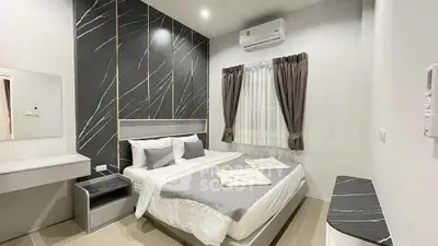 Modern bedroom with stylish decor and air conditioning, featuring a comfortable bed and elegant design.
