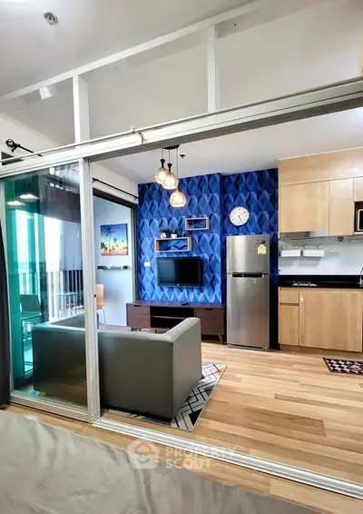 Modern open-plan living room with stylish decor and kitchen area, featuring a balcony view.