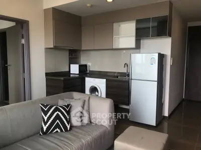 Modern apartment interior with sleek kitchen and cozy living area featuring stylish furniture.