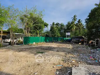 Vacant land plot surrounded by lush greenery, ideal for development opportunities.
