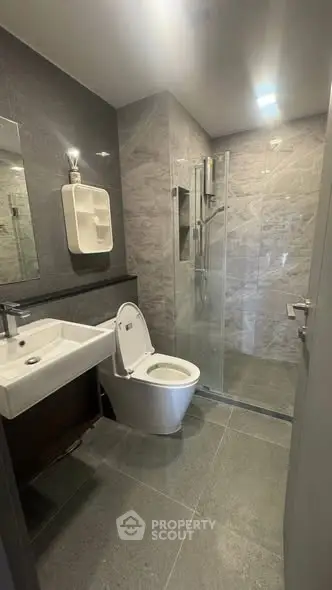 Modern bathroom with sleek design, featuring a glass shower and contemporary fixtures.