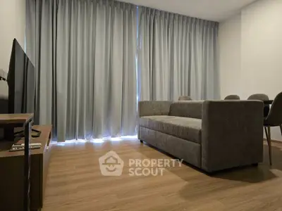 Modern living room with sleek furniture and floor-to-ceiling curtains