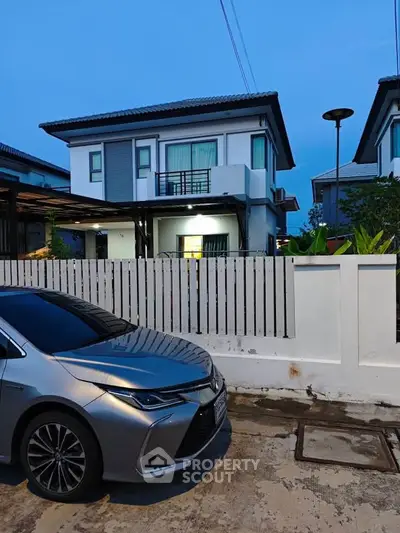 Modern two-story house with sleek design and spacious driveway in a suburban neighborhood.