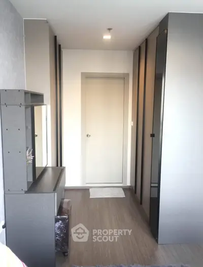 Modern bedroom with sleek wardrobe and stylish vanity in a contemporary apartment.