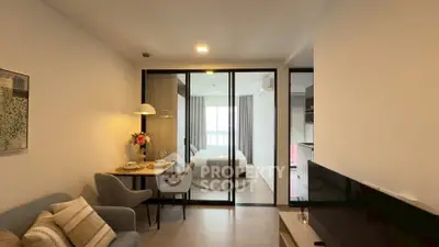 Modern open-plan living room with cozy dining area and bedroom view