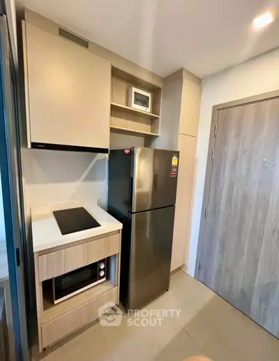 Modern compact kitchen with sleek appliances and wooden cabinetry