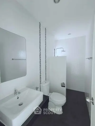 Modern minimalist bathroom with sleek fixtures and stylish tile accents.