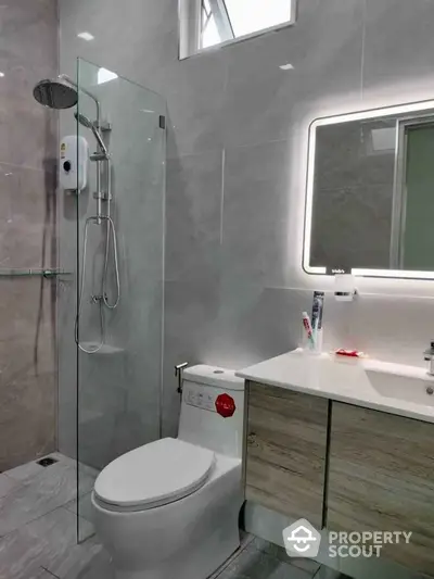 Modern bathroom with sleek shower and illuminated mirror