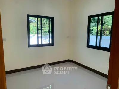 Bright empty room with two windows and glossy floor, perfect for customization.