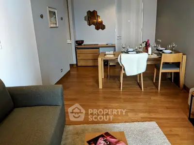 Stylish modern living room with dining area, wooden flooring, and elegant decor.