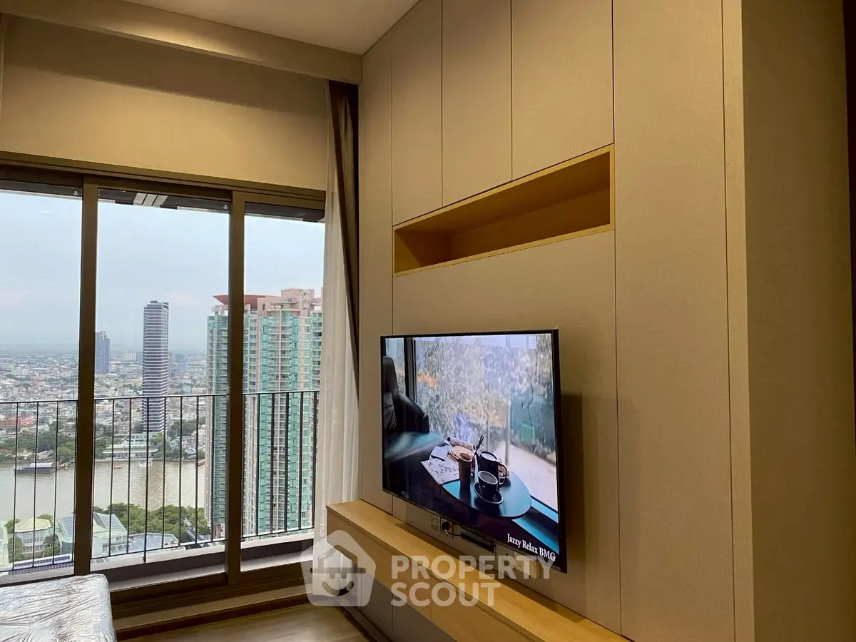 Modern living room with city view and sleek TV setup in high-rise apartment.