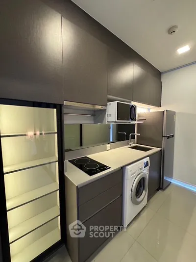 Modern kitchen with sleek cabinets, washing machine, and built-in appliances