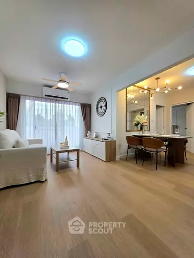 Spacious modern living room with dining area, wooden flooring, and elegant decor.