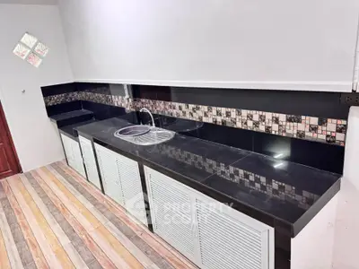 Modern kitchen with sleek black countertops and stylish backsplash