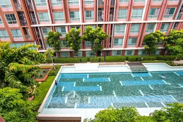 Luxurious apartment complex with stunning pool and lush greenery, perfect for modern living.