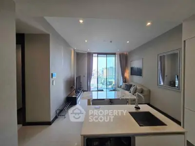 Modern living room with open kitchen and city view, featuring sleek design and ample natural light.