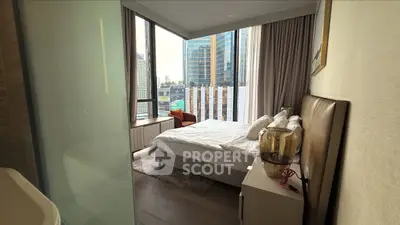Luxurious bedroom with city view, modern decor, and floor-to-ceiling windows in high-rise apartment.