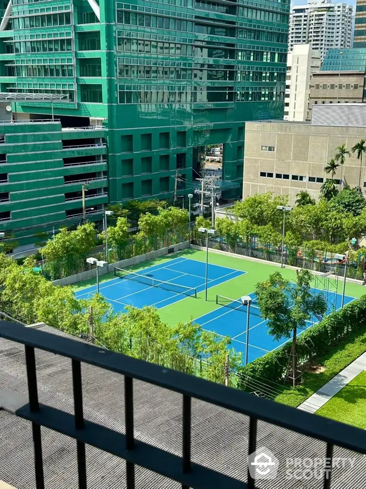 Stunning view of modern tennis courts surrounded by lush greenery and urban architecture.