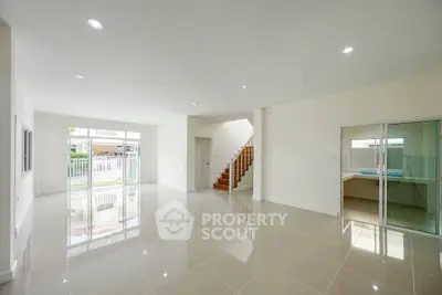 Spacious modern living room with glossy tile flooring and large windows for natural light.