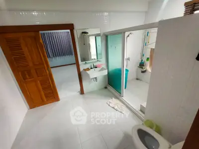Spacious bathroom with modern shower and wooden accents