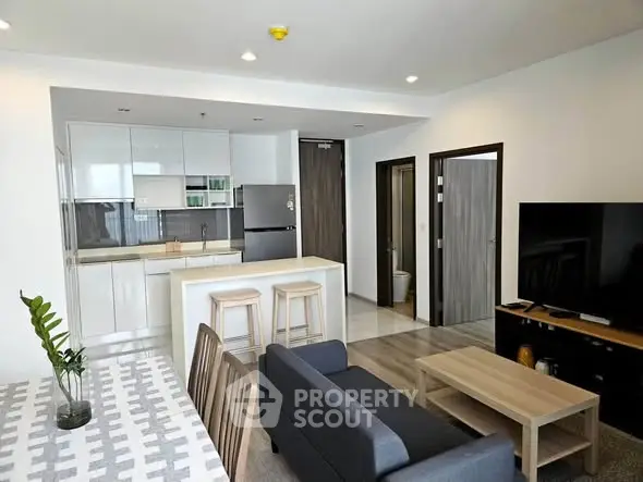 Modern open-plan living room with sleek kitchen and stylish furniture