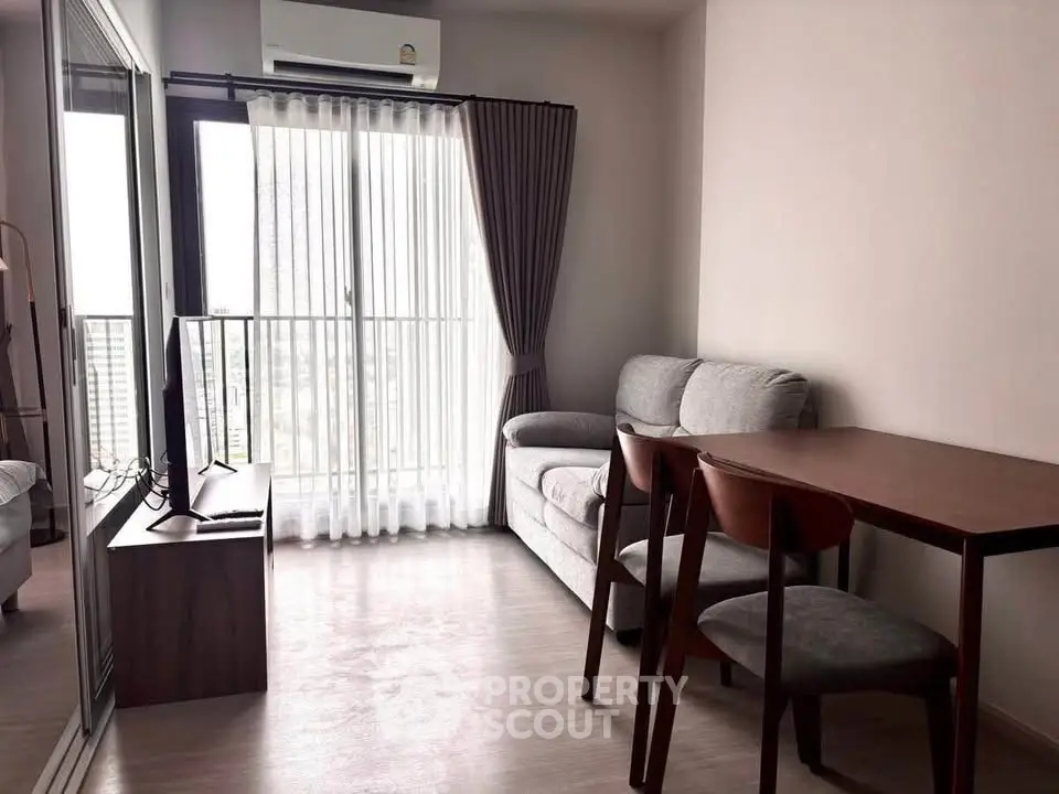 Cozy living room with modern furniture and large window offering natural light.
