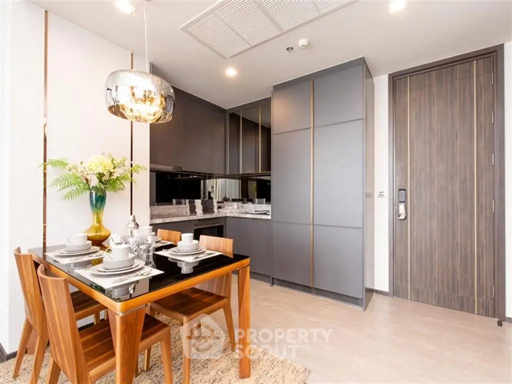 Modern dining area with sleek kitchen cabinets and elegant table setting in a contemporary apartment.