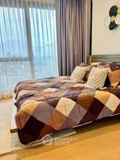 Cozy bedroom with stylish decor and large window for natural light