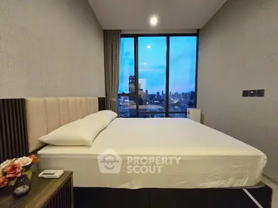 Modern bedroom with city view, featuring a comfortable bed and stylish decor.