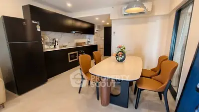 Modern kitchen and dining area with sleek black cabinets and stylish dining table.