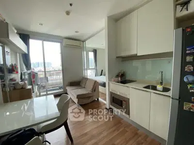 Modern open-layout kitchen and living area with balcony view in urban apartment