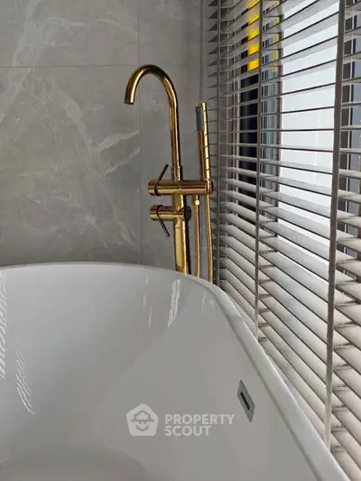 Luxurious bathroom with elegant gold fixtures and modern bathtub