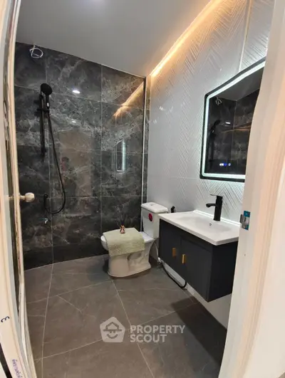 Modern bathroom with sleek design, featuring a stylish shower and elegant vanity.